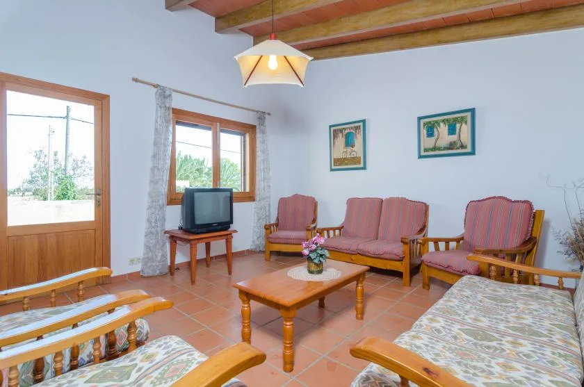 Una sala de estar con asientos, una mesa de centro y un televisor.