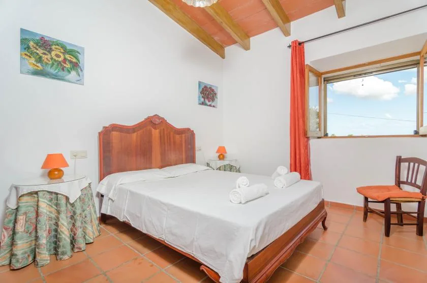 Un dormitorio con una cama grande, mesitas de noche y una ventana con vista al cielo.
