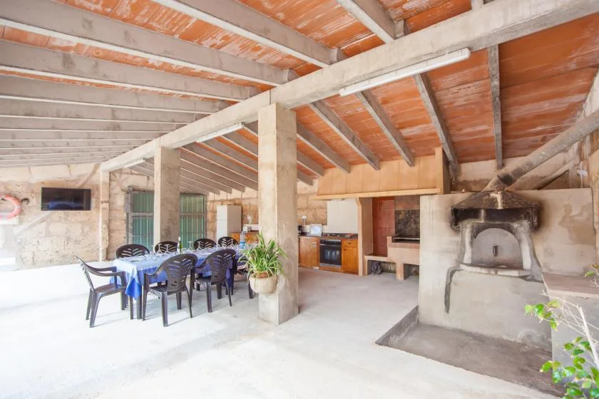 Una zona rústica para comer y cocinar, con una mesa larga bajo vigas expuestas.