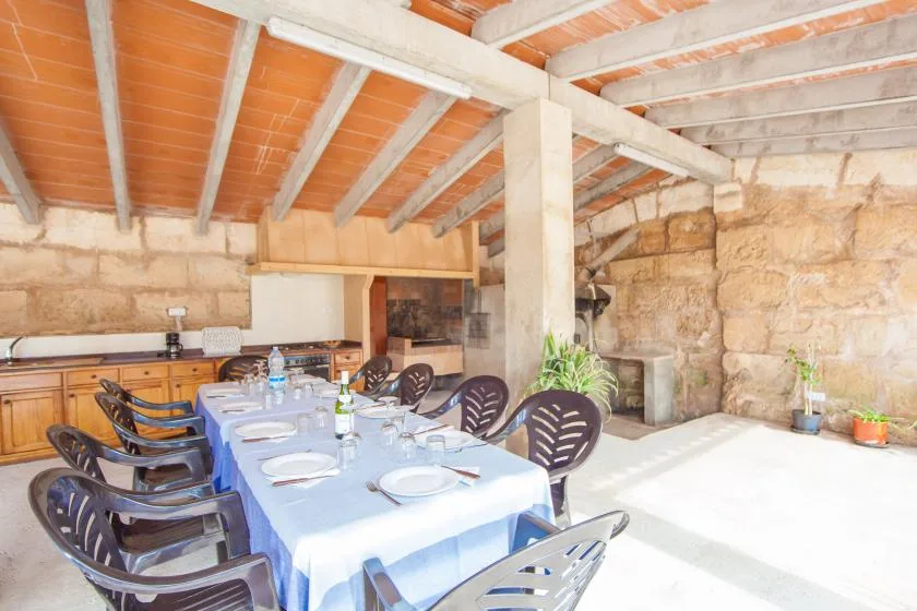 Un comedor rústico con una mesa larga preparada para comer.