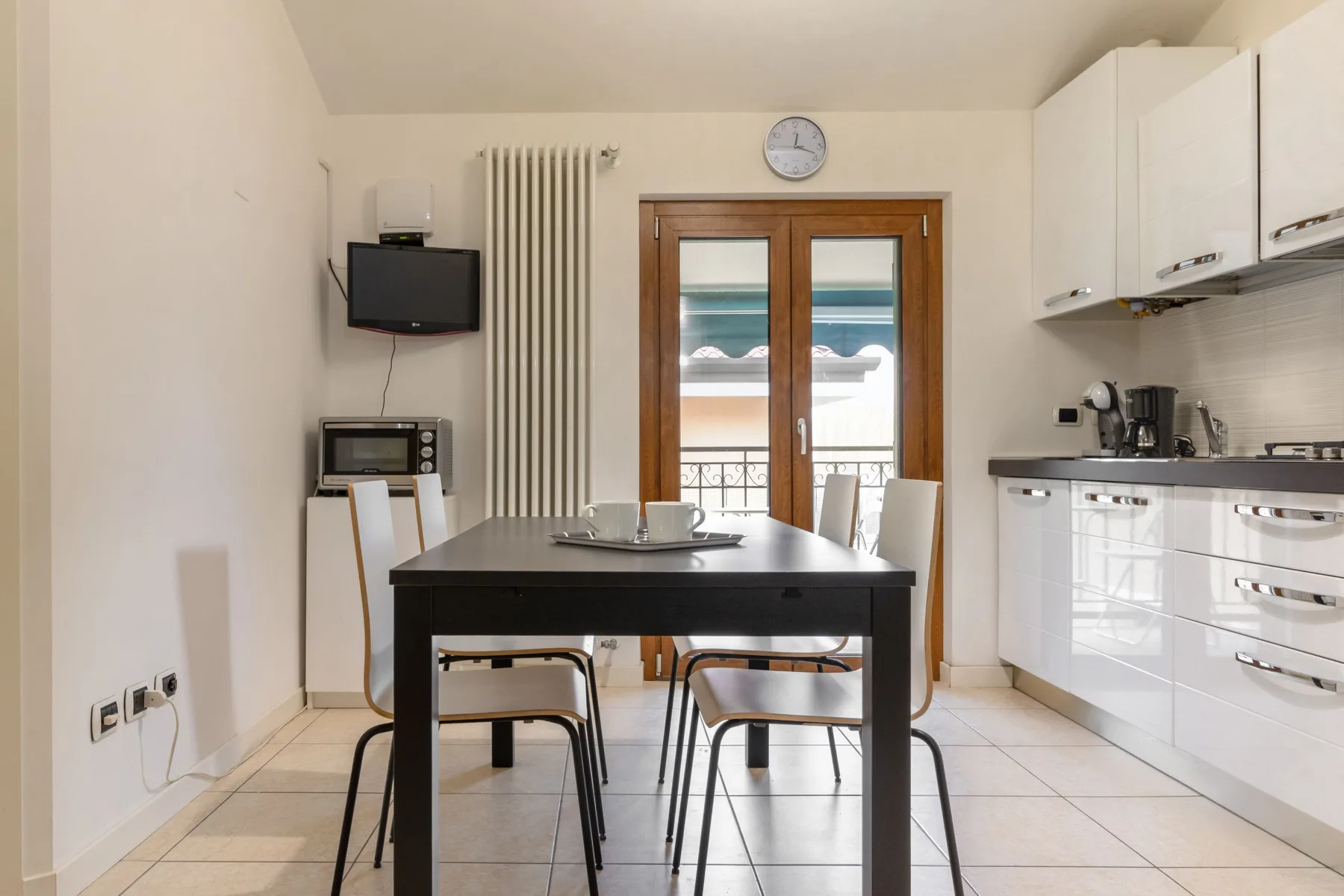 Comedor con una mesa oscura junto a una ventana luminosa.