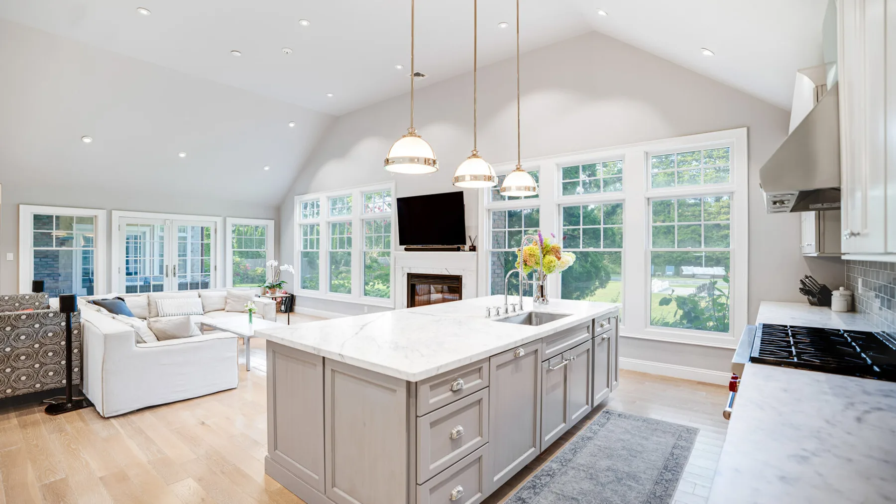 A bright open-plan kitchen and living area with a large island and broad windows.