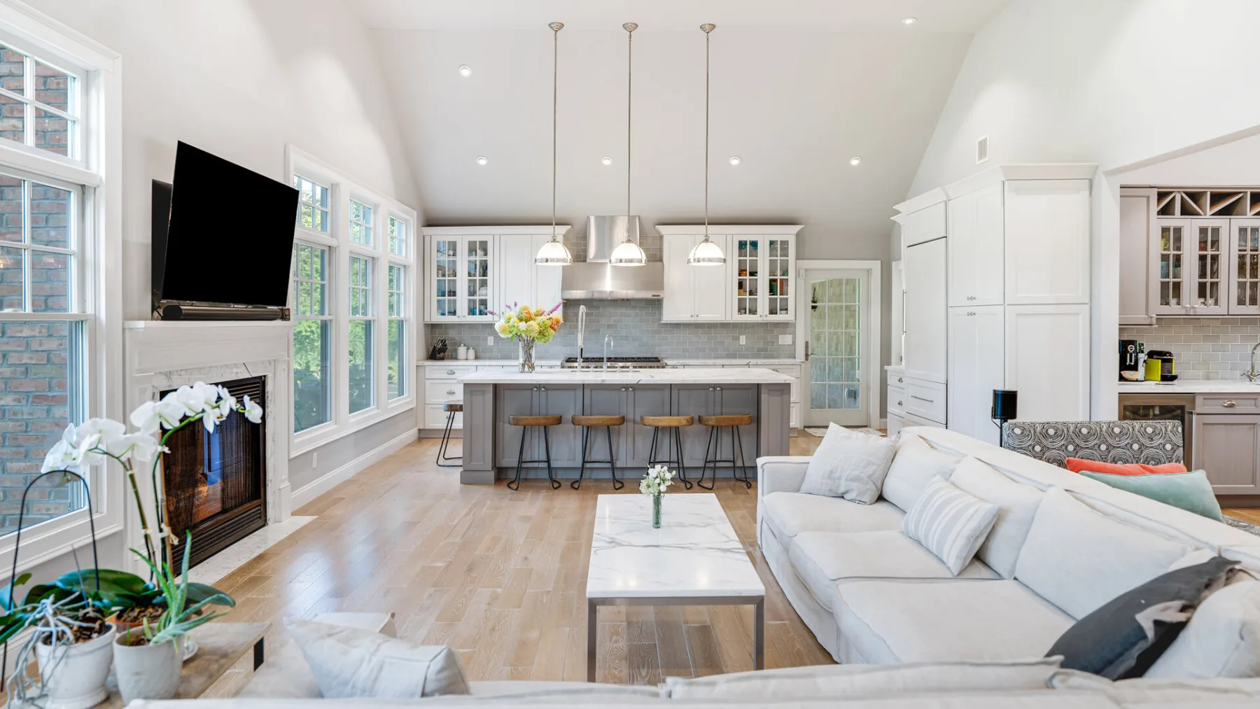 A bright open-plan living room and kitchen with a long island and seating.