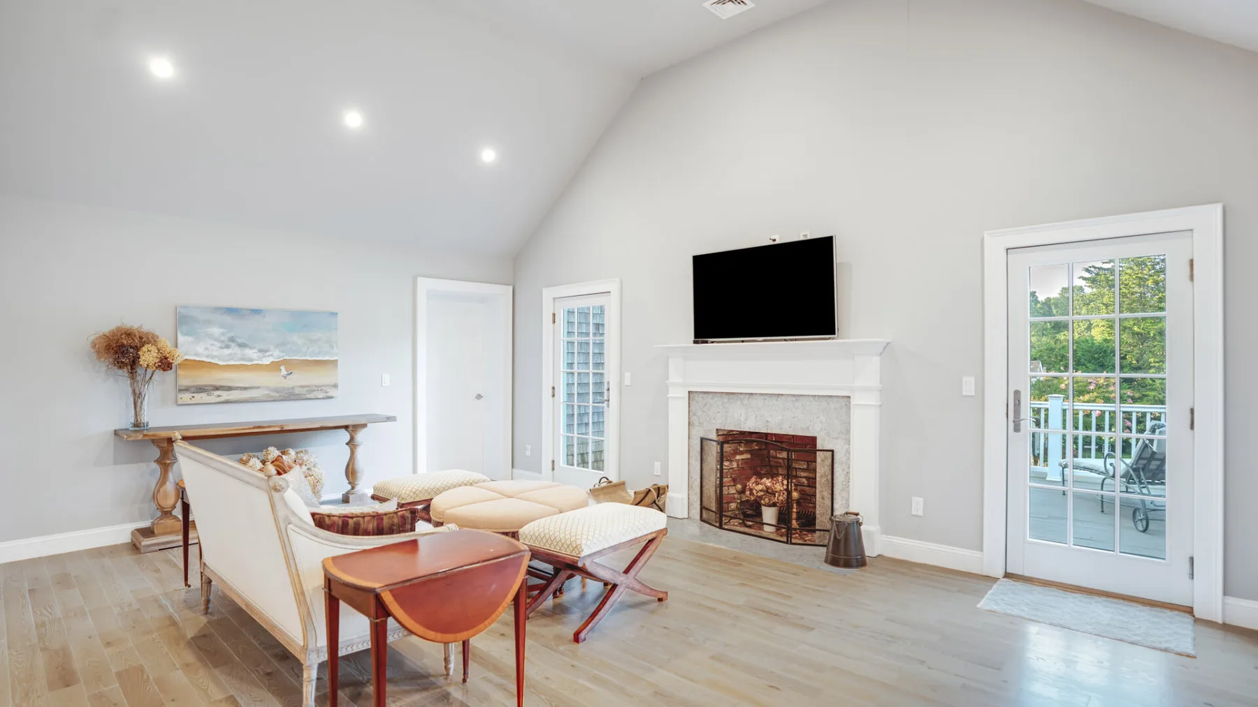 A bright living room with seating, a fireplace, and a television.