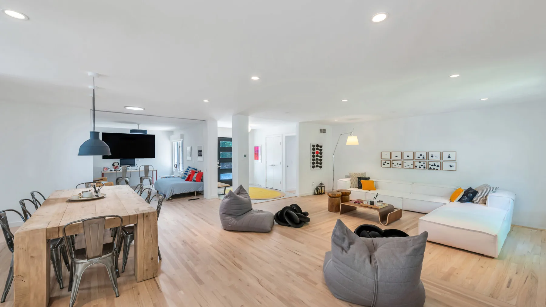An open-plan living room and dining area with low seating and a large table.