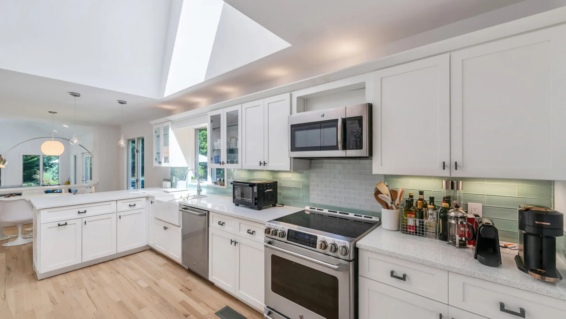A bright kitchen with white cabinets, a stove, and a large central island.