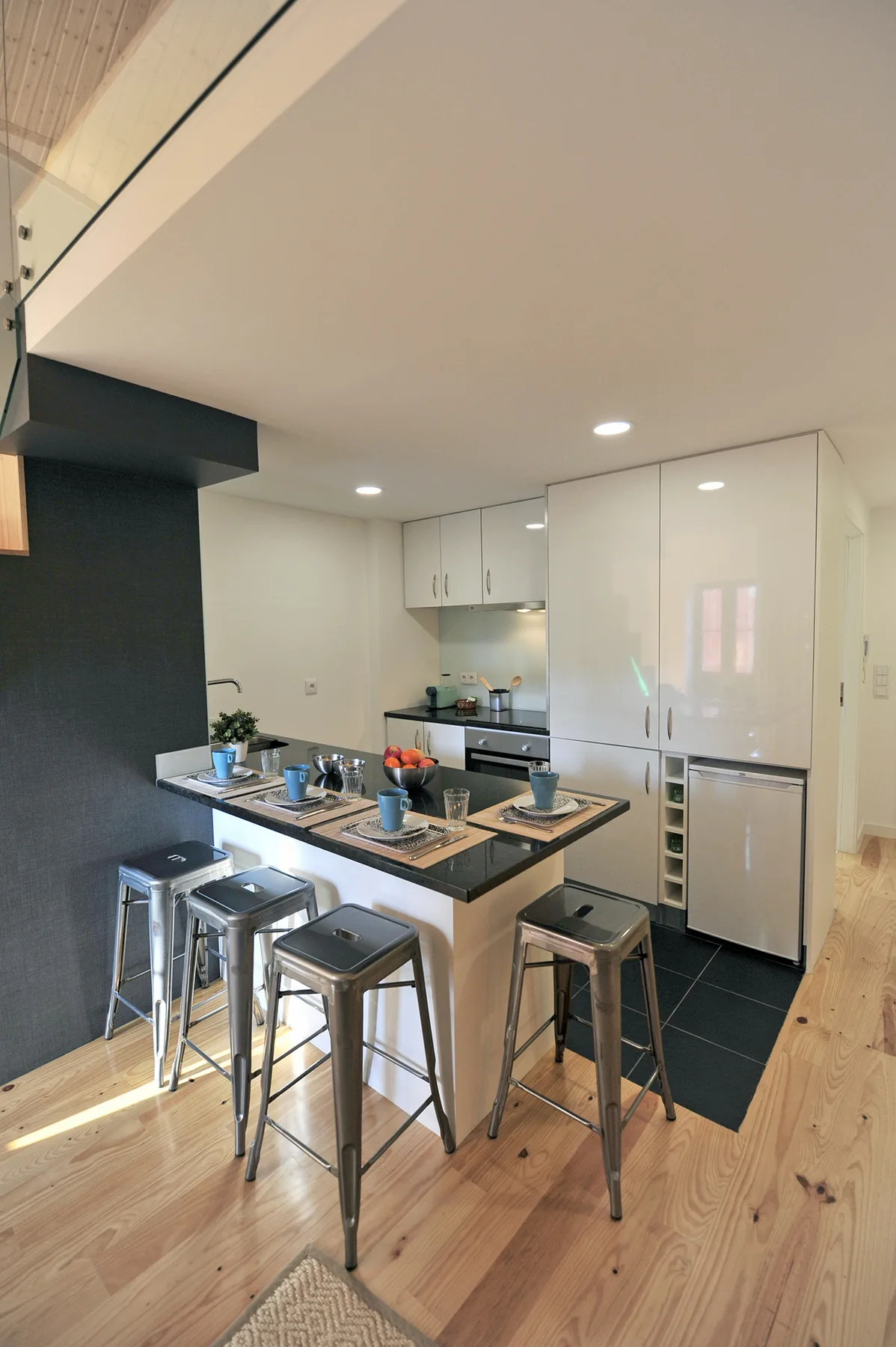 A modern kitchen with an island, bar seating, and stainless steel appliances.