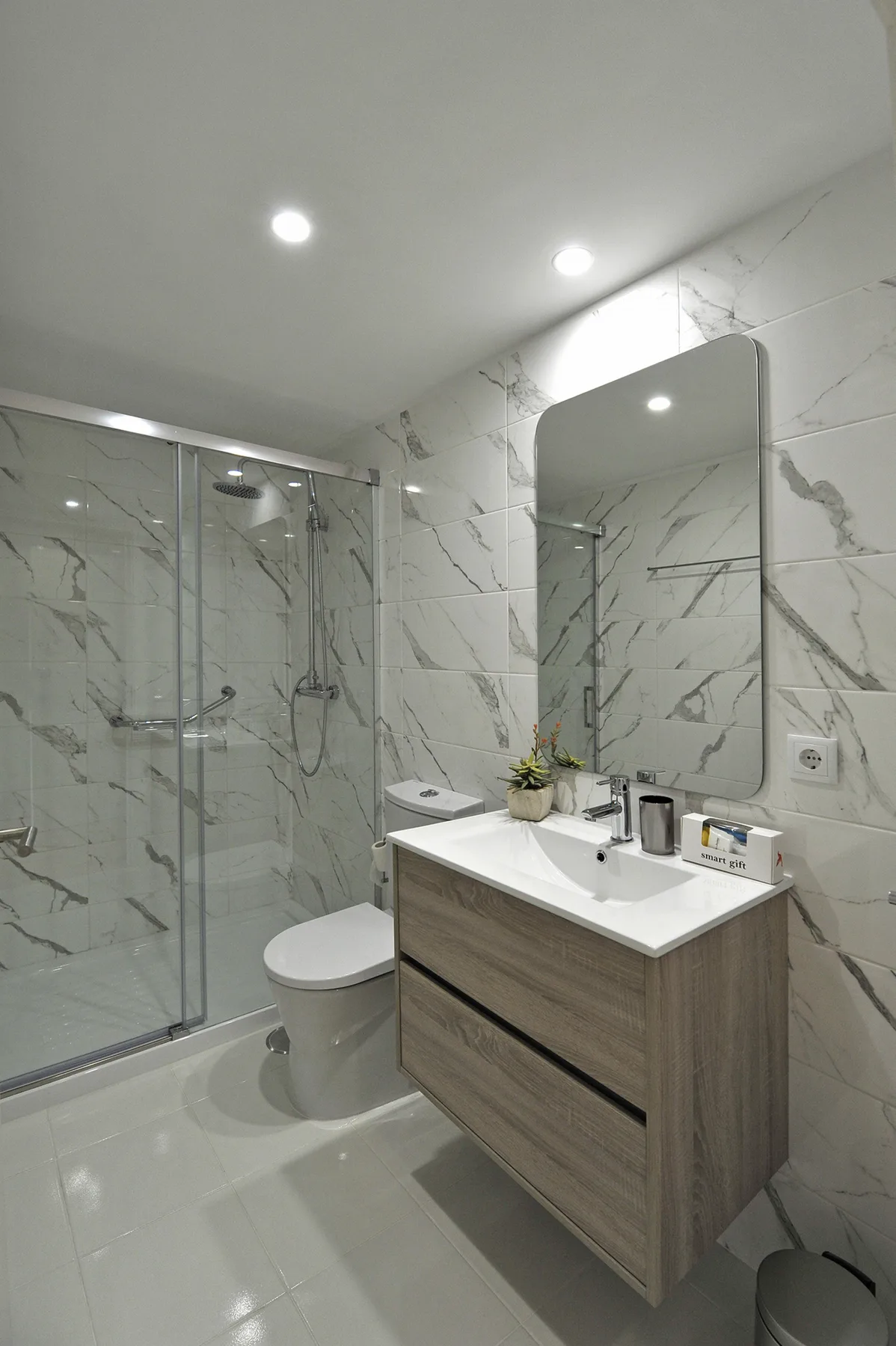 A modern bathroom with a glass shower and a vanity beneath a mirror.