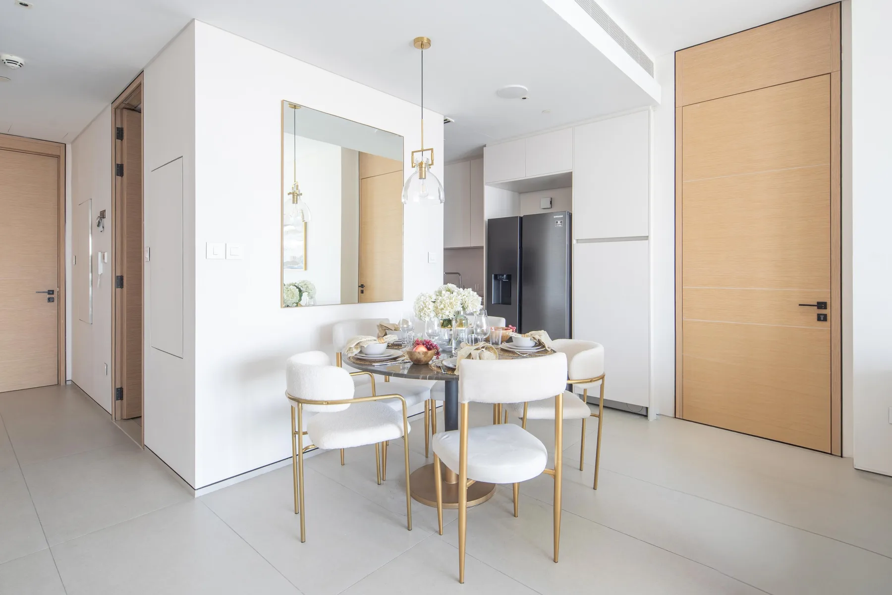 Un comedor luminoso con mesa, sillas y una cocina contigua.