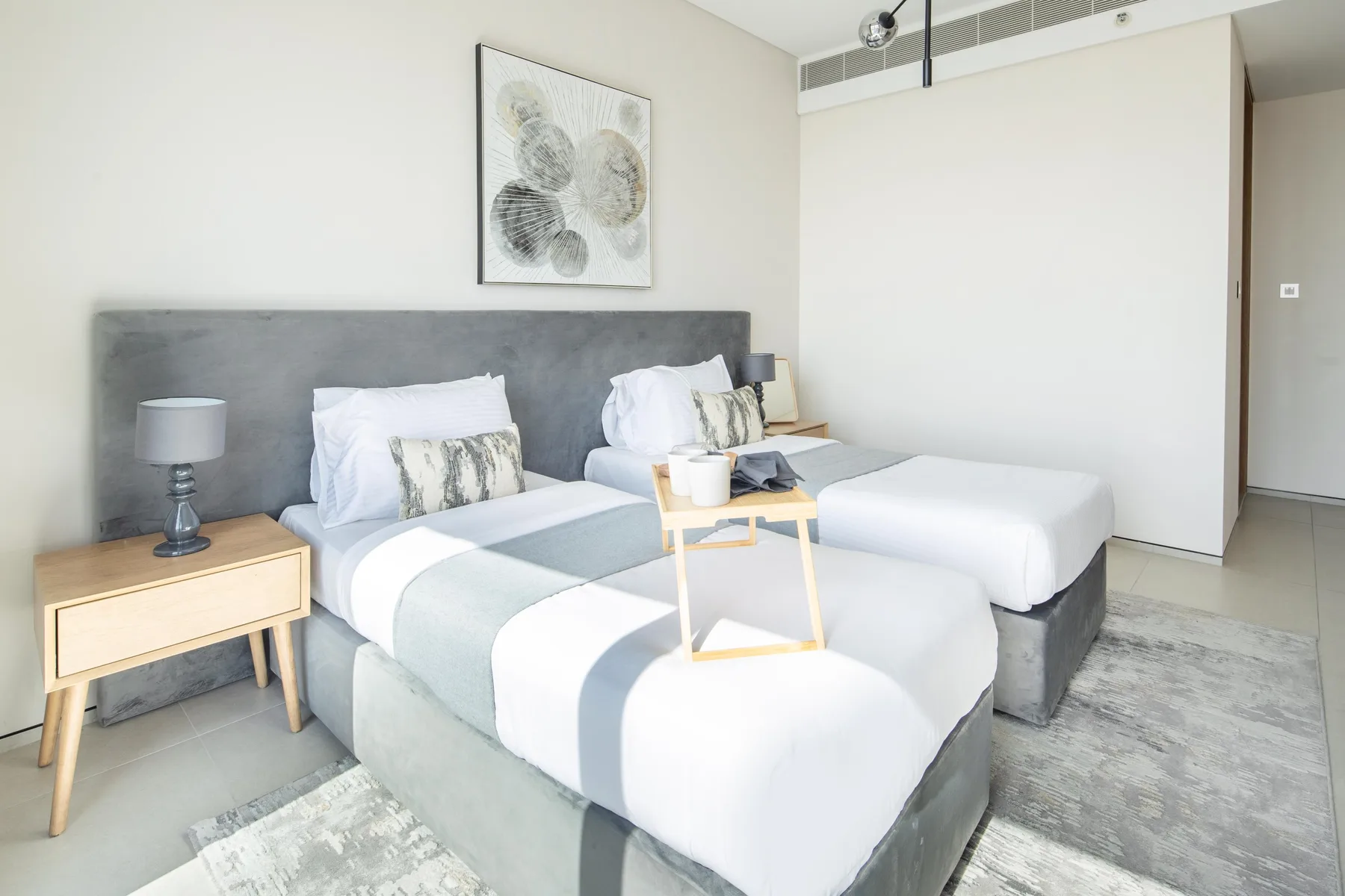 Un dormitorio luminoso con dos camas dispuestas una junto a la otra.
