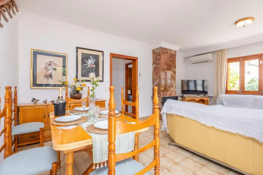 A bedroom with a dining table and seating beside the bed.