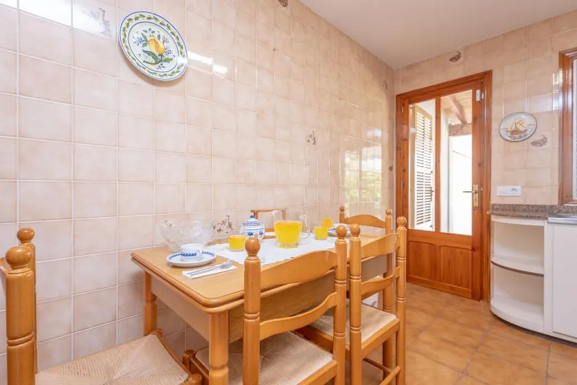 A tiled dining area with a wooden table and chairs.