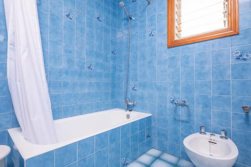A tiled bathroom with a bathtub, shower, and sink.