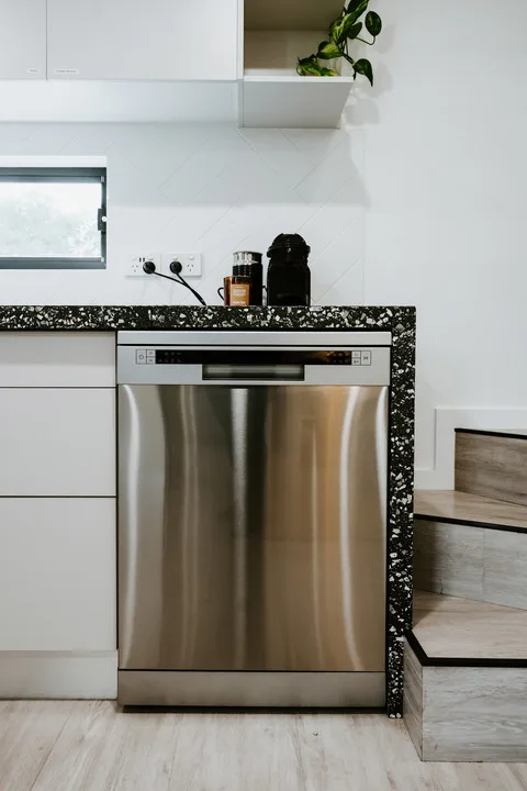 Una cocina moderna con un lavavajillas de acero inoxidable bajo la encimera.