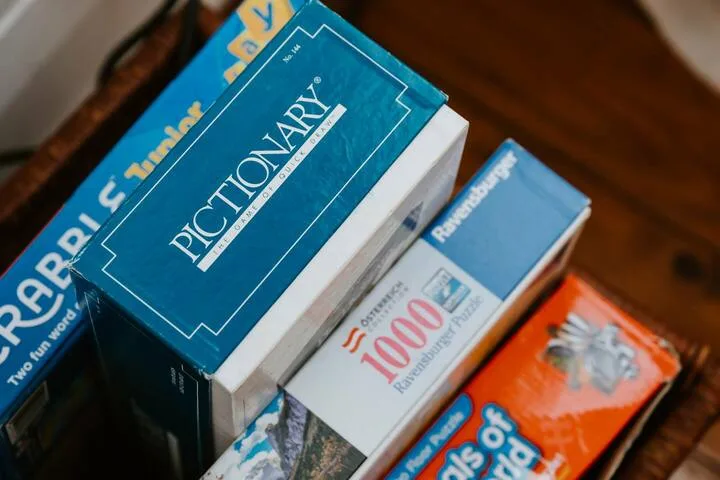 Primer plano de libros y materiales impresos apilados sobre una superficie de madera.