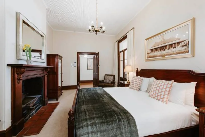 Un dormitorio con una cama grande, muebles de madera oscura y una lámpara de araña.