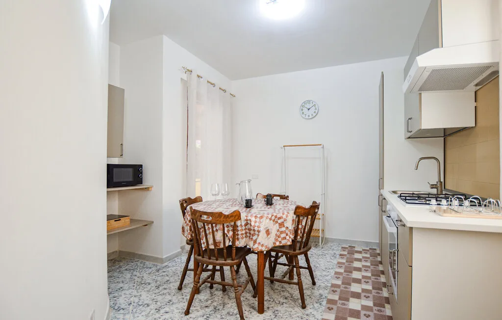 Comedor con una mesa y sillas junto a una cocina compacta.