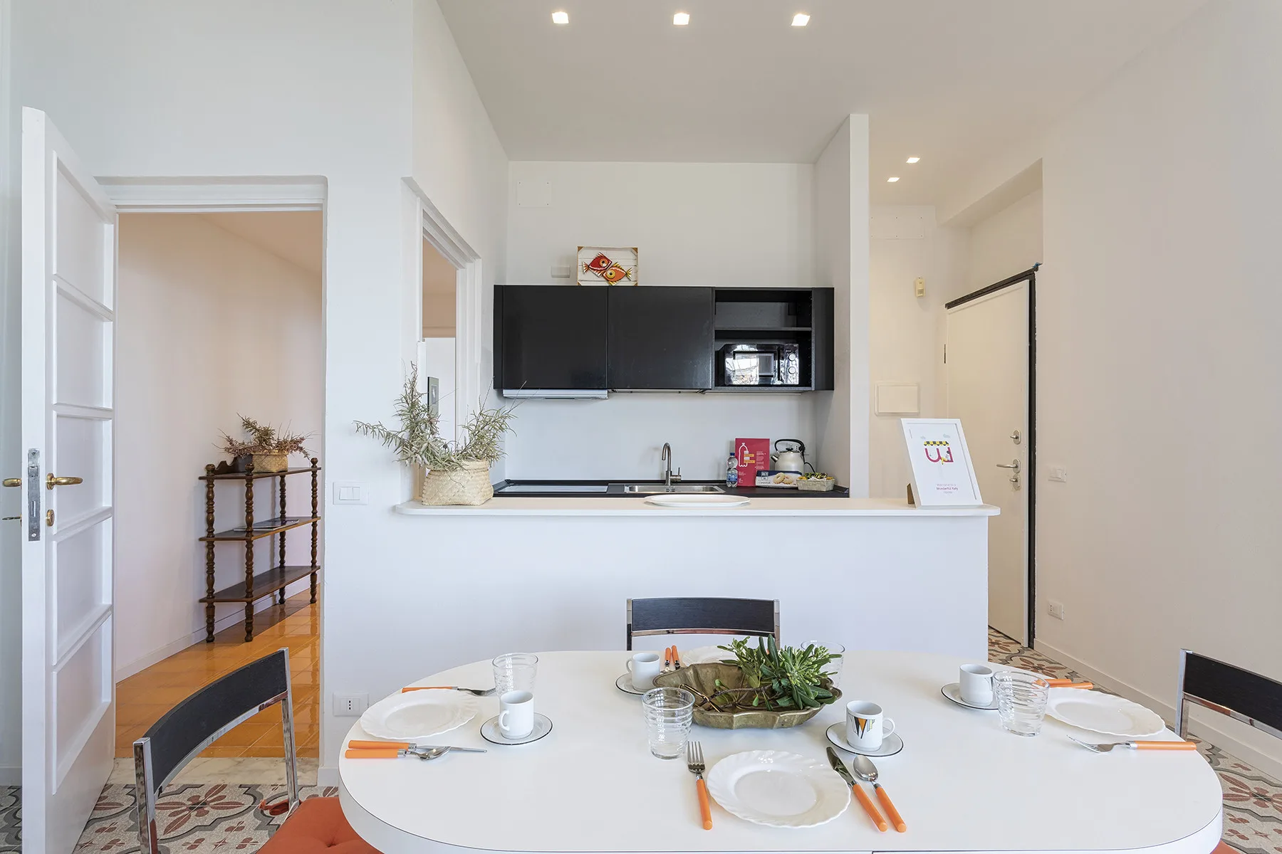 A bright dining area with a set table in front of a kitchen counter.