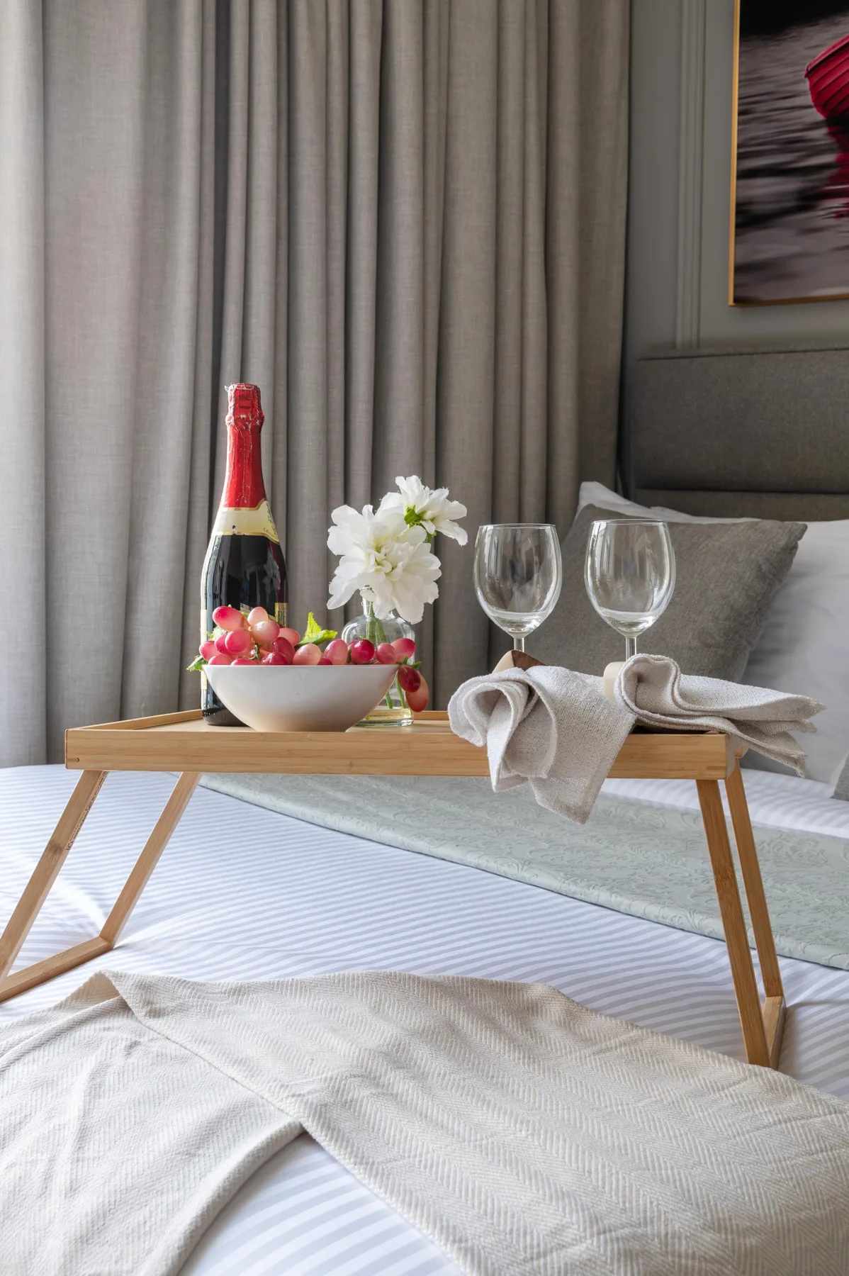 Una zona de descanso en un dormitorio con una mesa baja adornada con bebidas y flores.
