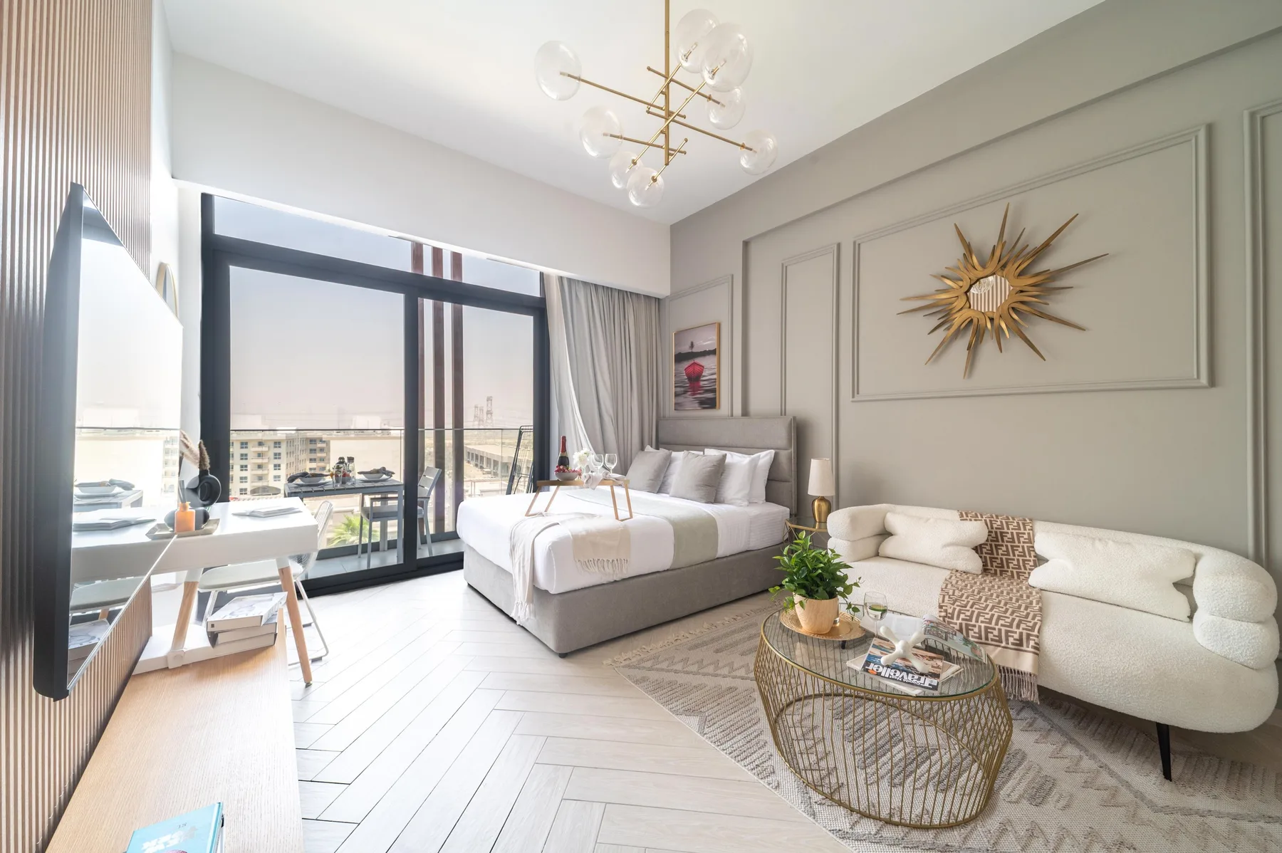 Dormitorio con una cama y una zona de estar junto a grandes ventanales.
