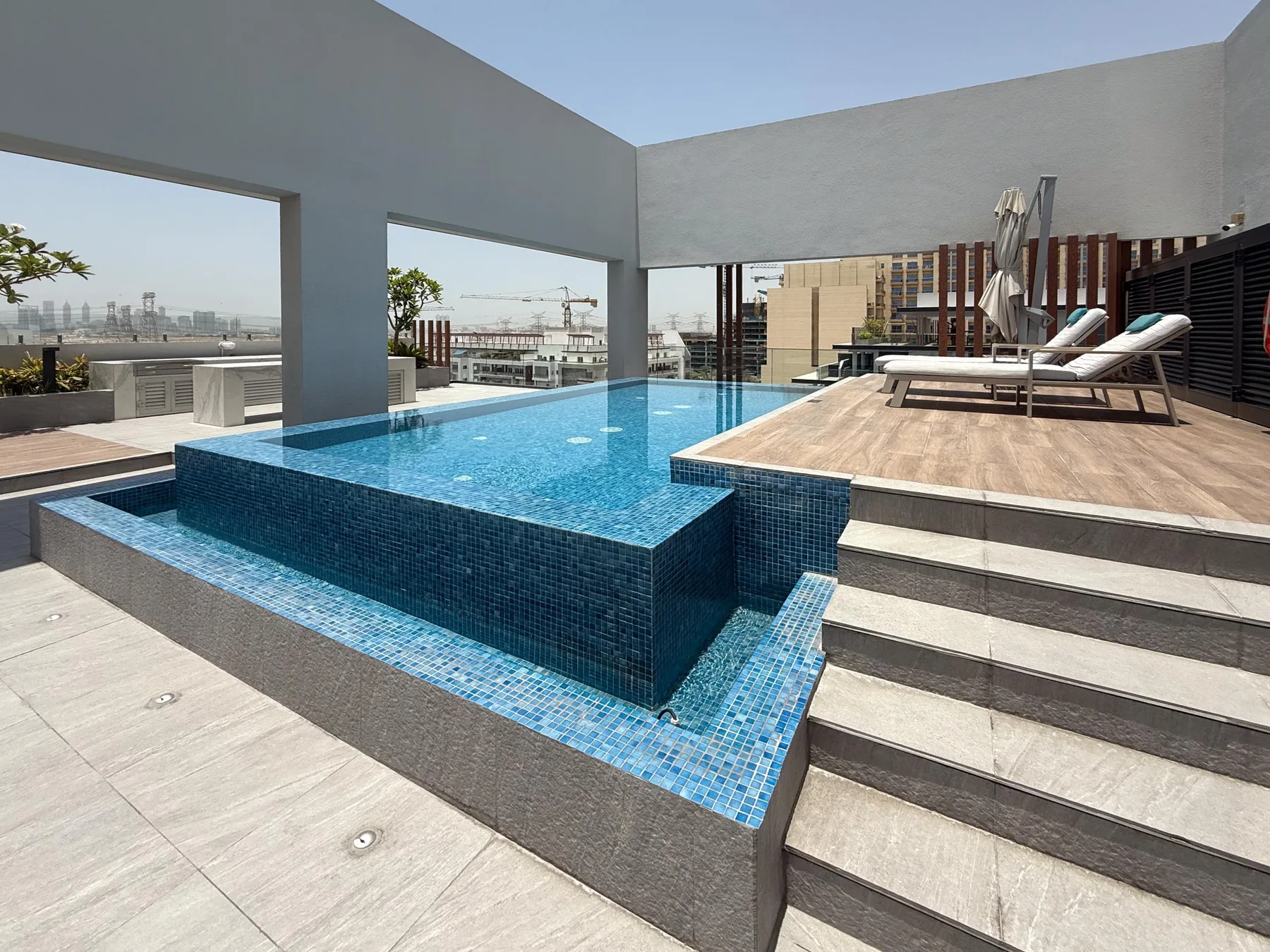 Una piscina en la azotea está junto a amplios escalones y asientos de descanso.