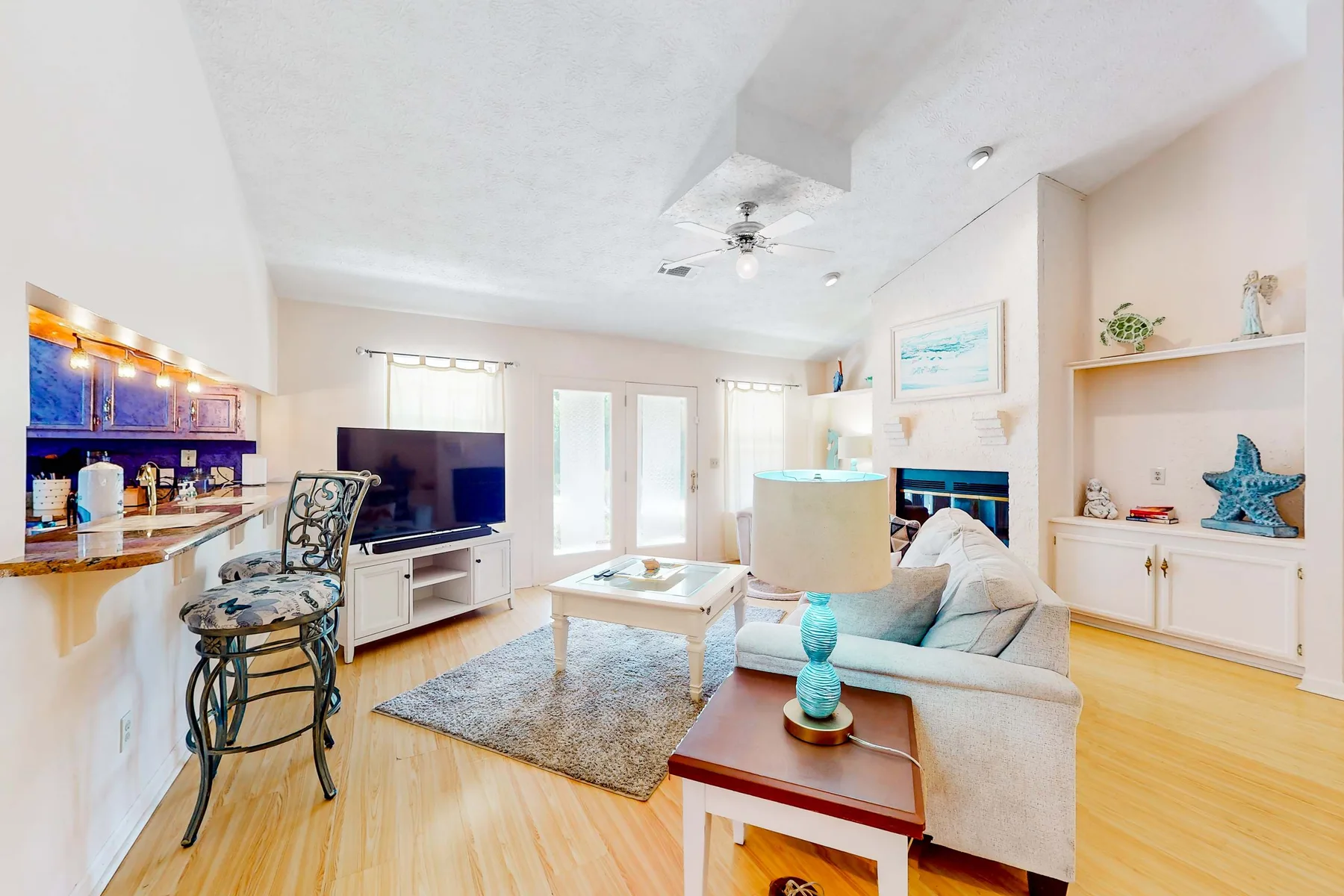 A bright living room with seating, a television, and a coffee table.