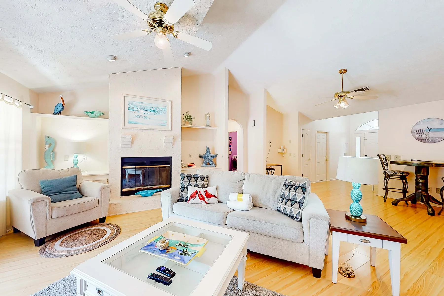 A bright living room with light-colored seating and a white coffee table.