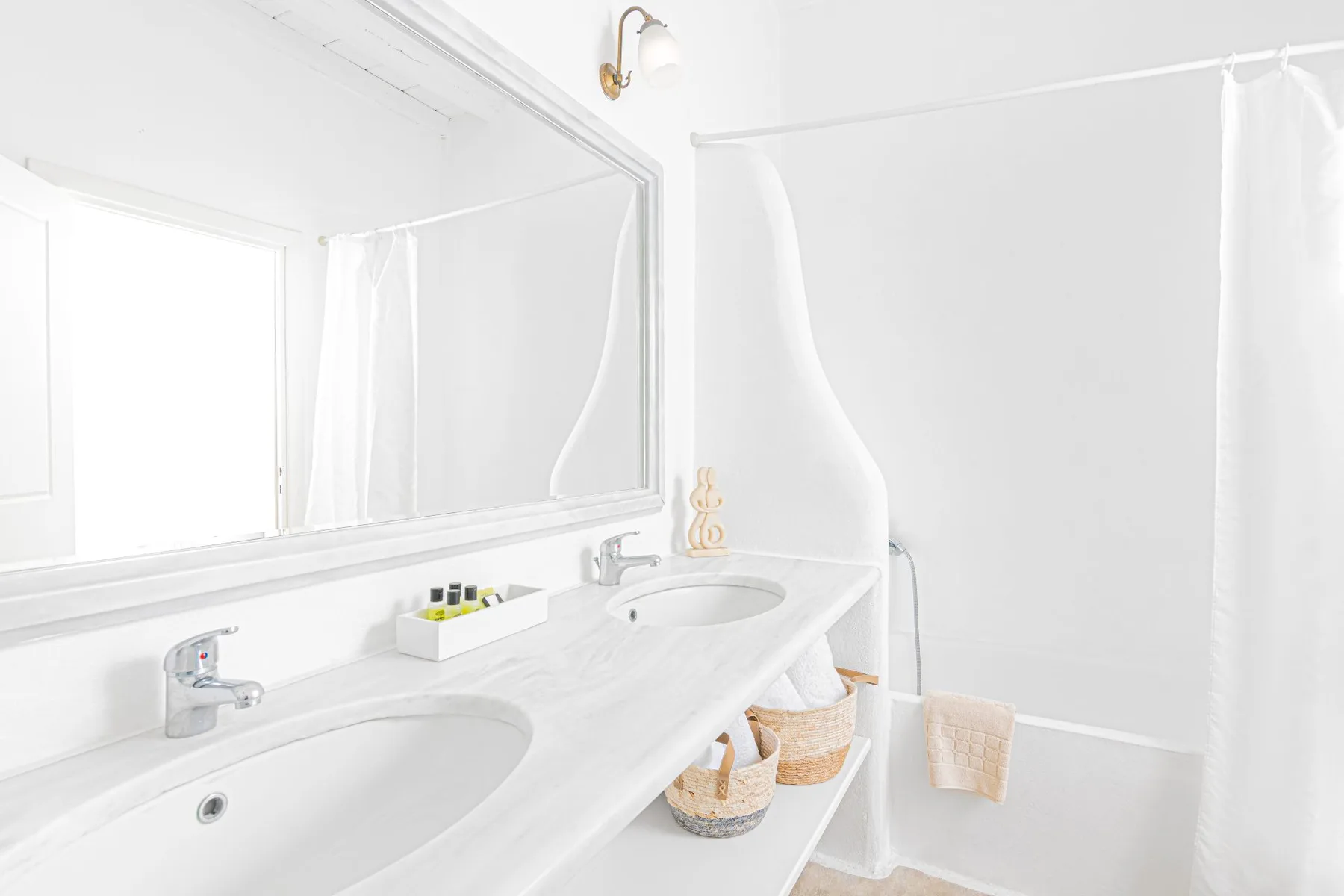 A bright bathroom vanity with two sinks and a large mirror.