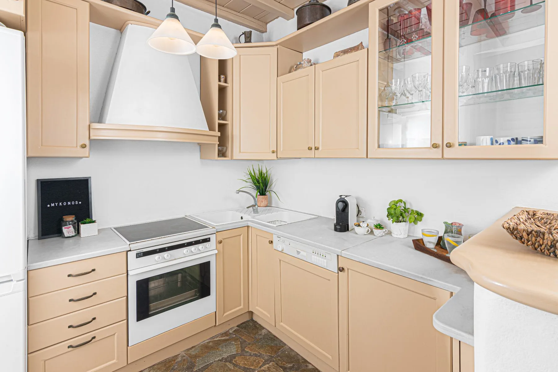 A bright kitchen with light wood cabinets and a countertop.