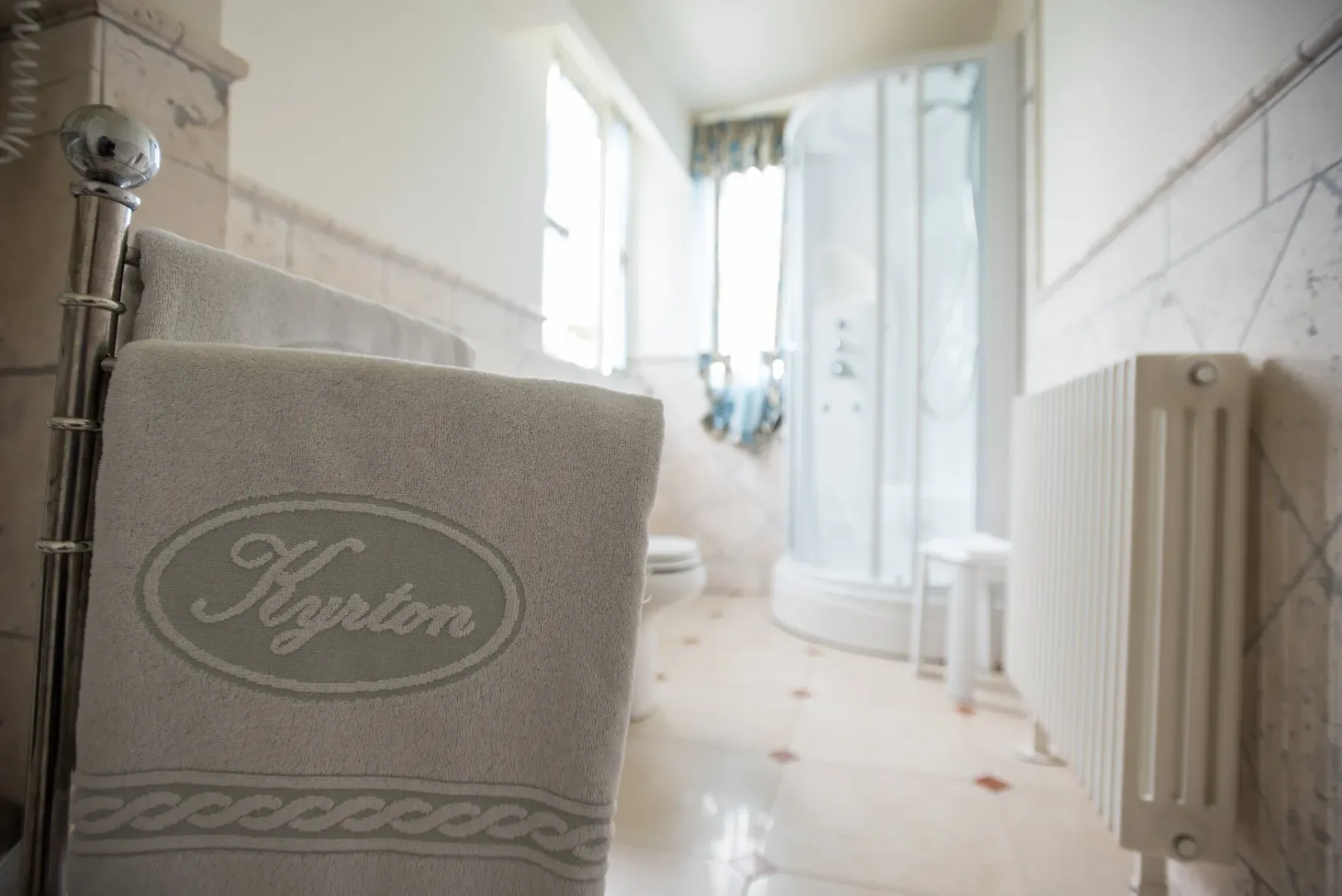 Baño con suelo de baldosas y cortina de ducha.
