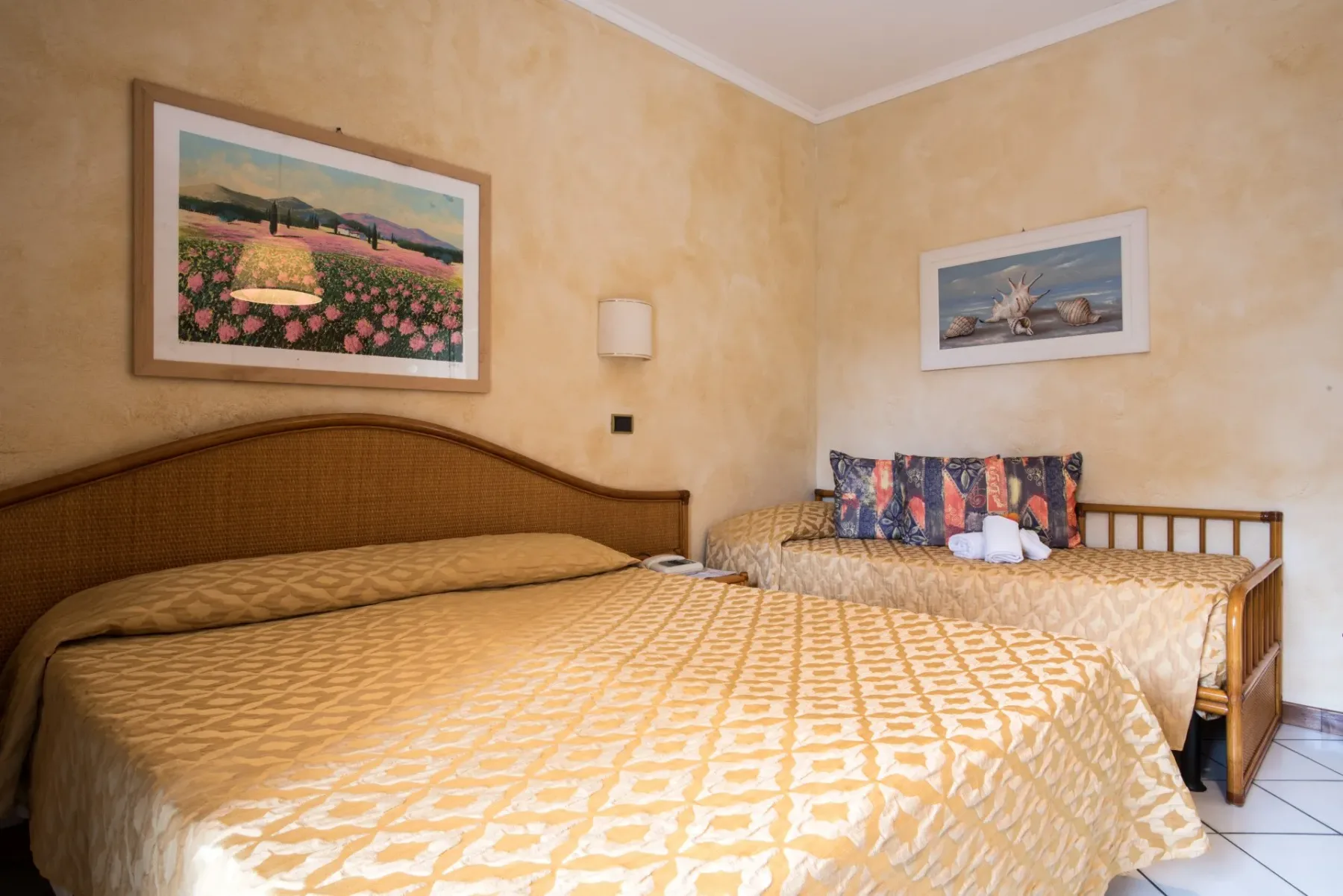 Dormitorio con una cama grande y una colcha estampada.
