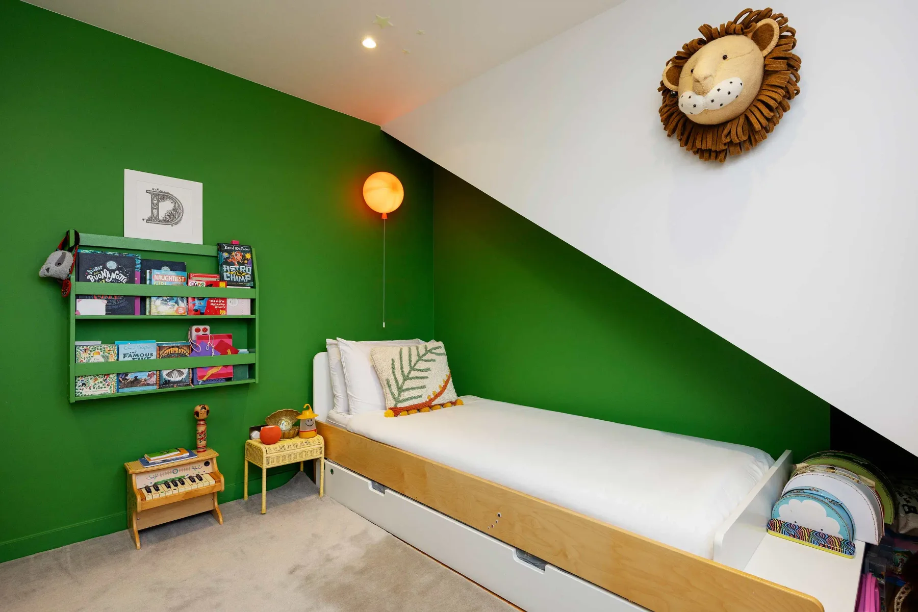 A children’s bedroom with a single bed and green walls.