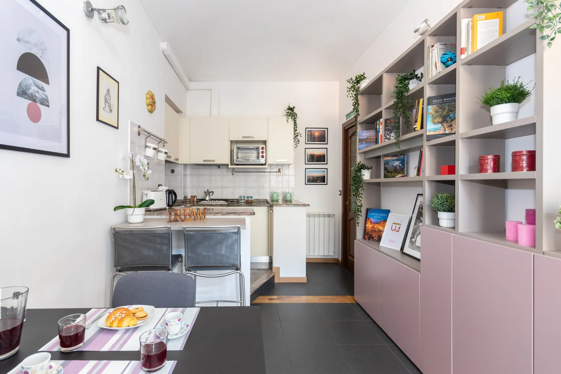 A compact kitchen and dining area with open shelving and a table.