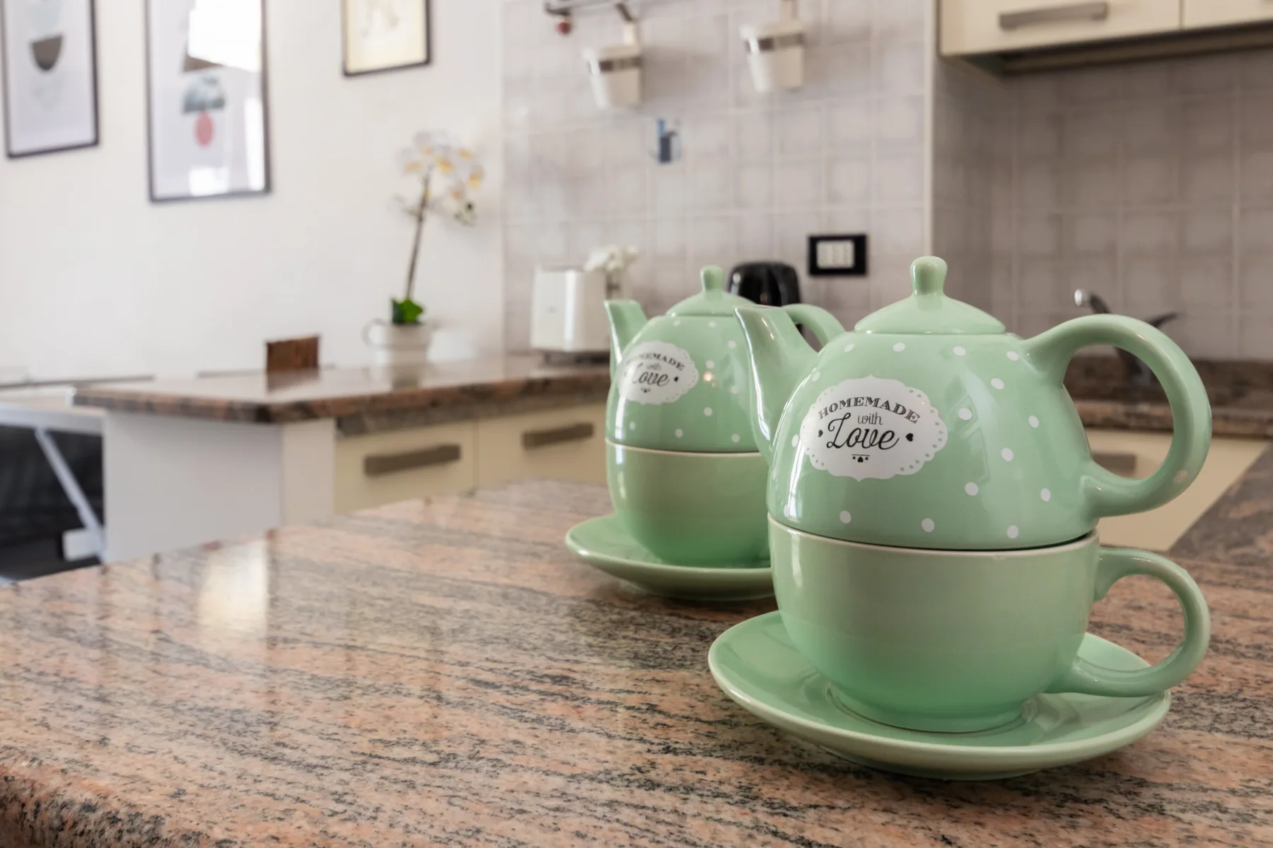A kitchen counter displays a mint-green teapot and matching cups.