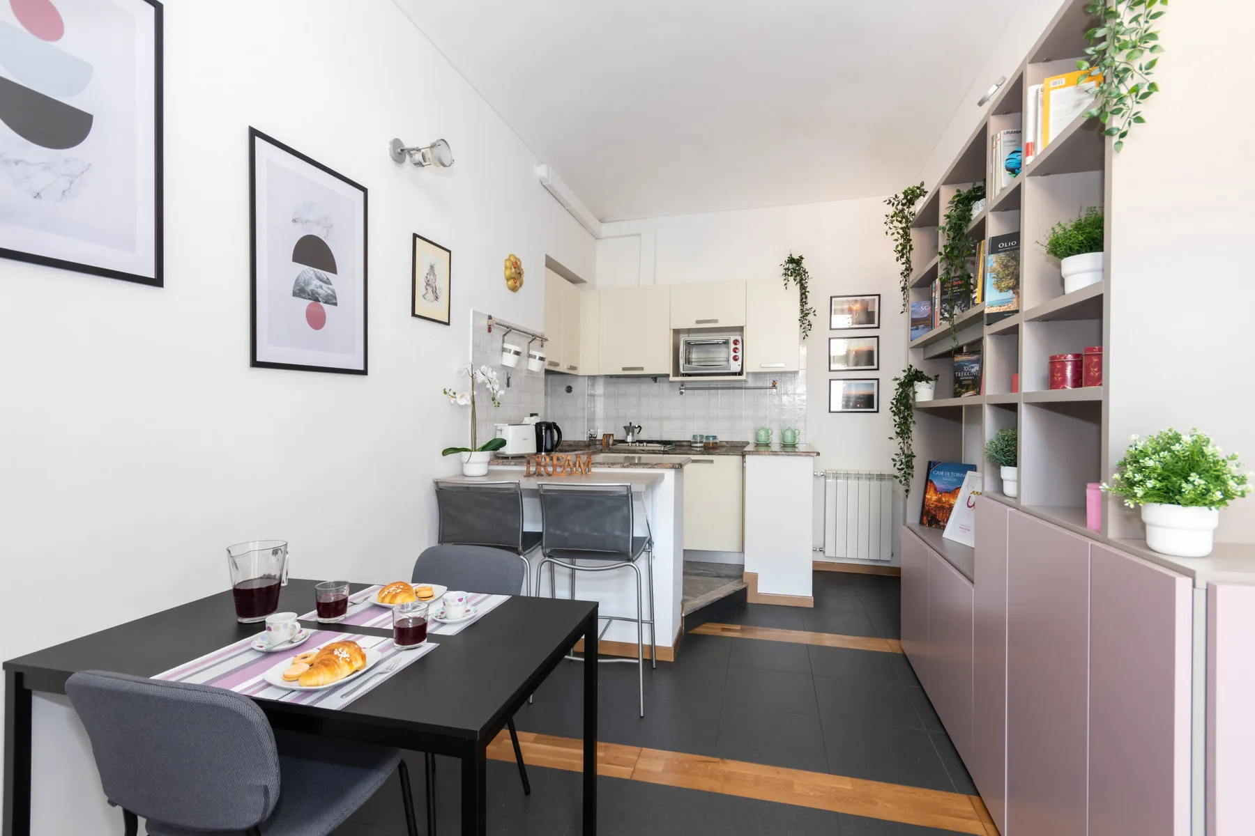 A bright kitchen and dining area with a table and open shelving.