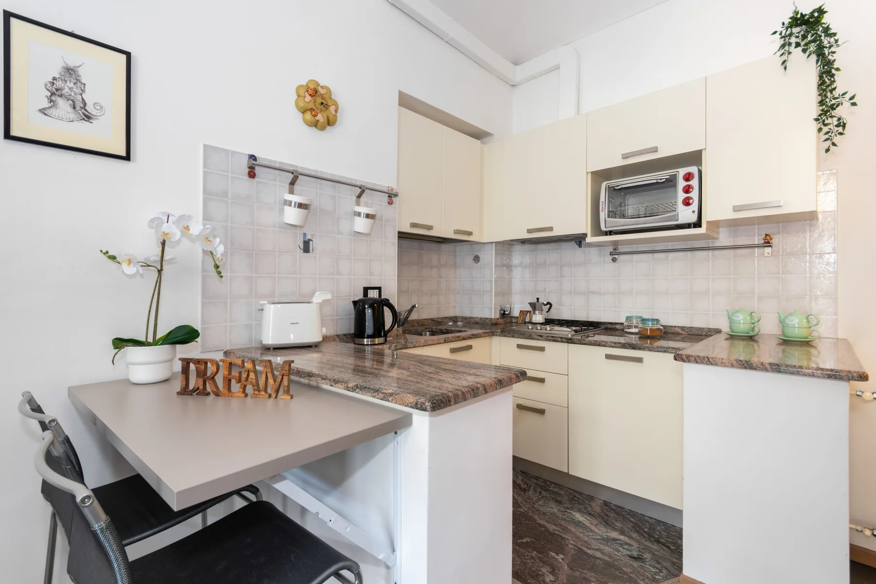 A bright kitchen with a dining table and cream-colored cabinets.