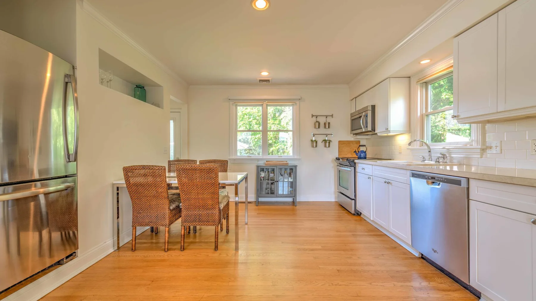A bright kitchen with a dining table and woven seating.