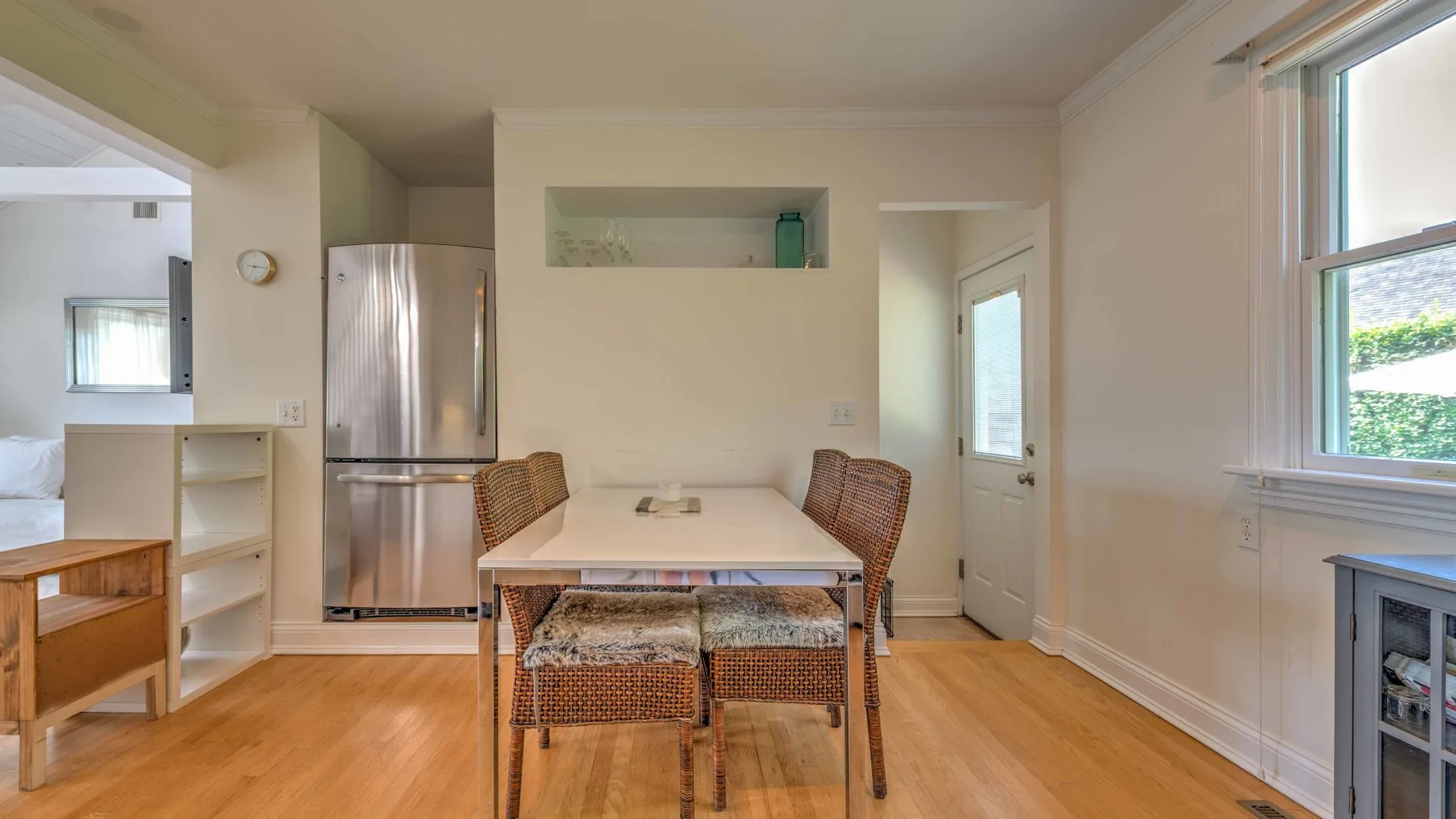 A dining area with a table and woven seating beside the kitchen.