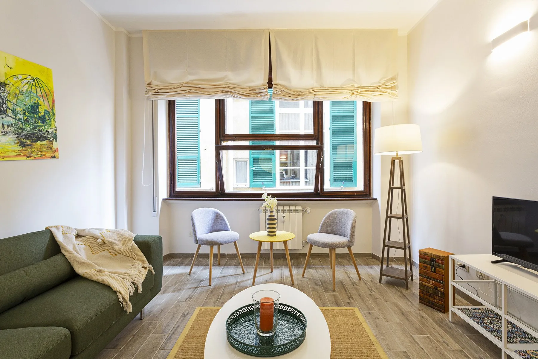 A living room with seating arranged around a coffee table beside a large window.