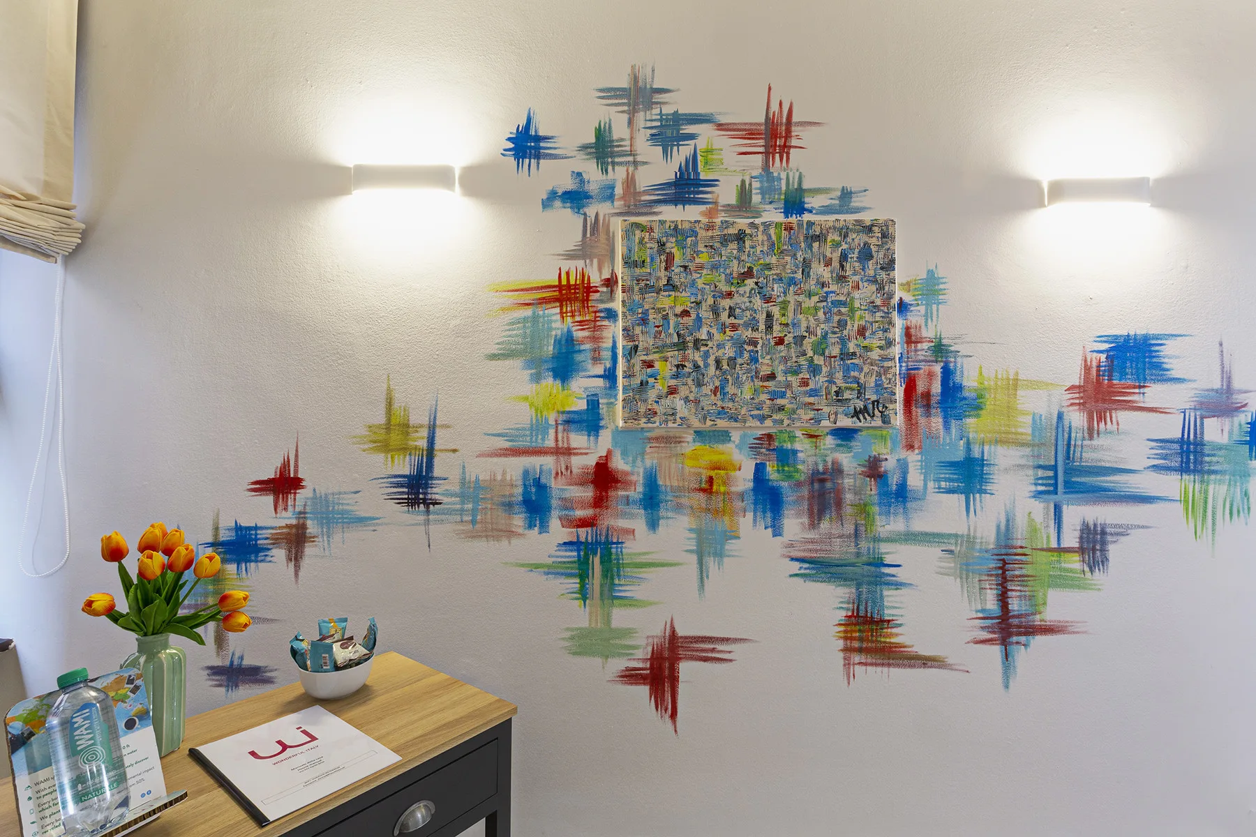 A small reception area with colorful wall art above a counter.