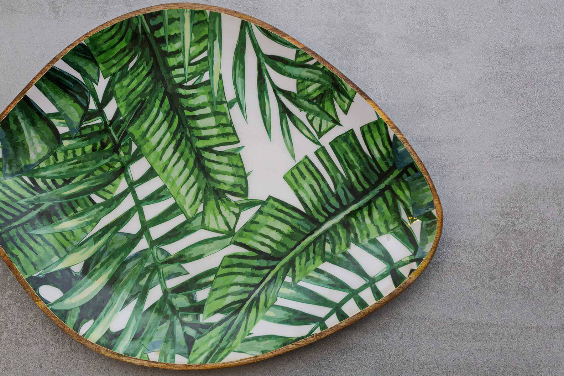 A leaf-patterned decorative tray rests on a gray surface.