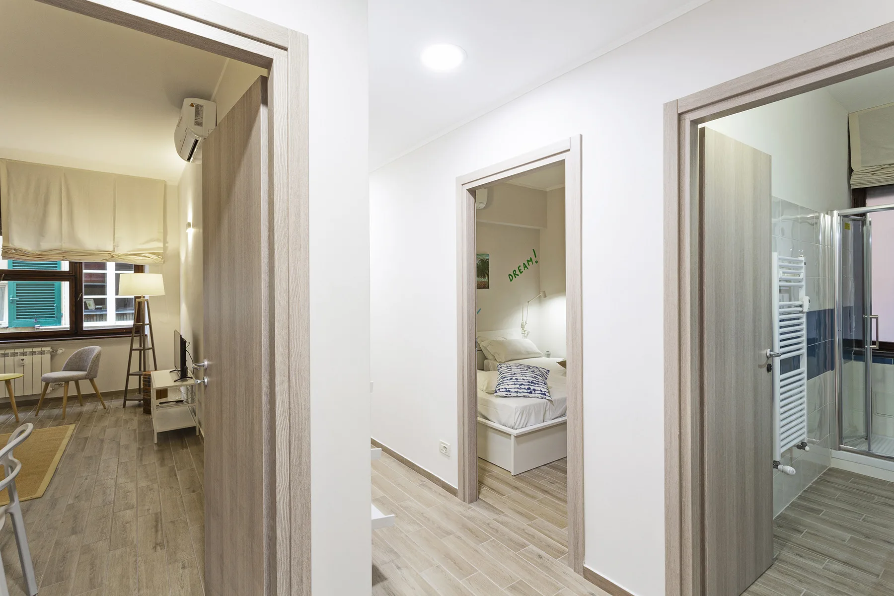 A bright interior hallway opens onto a bedroom and a bathroom.