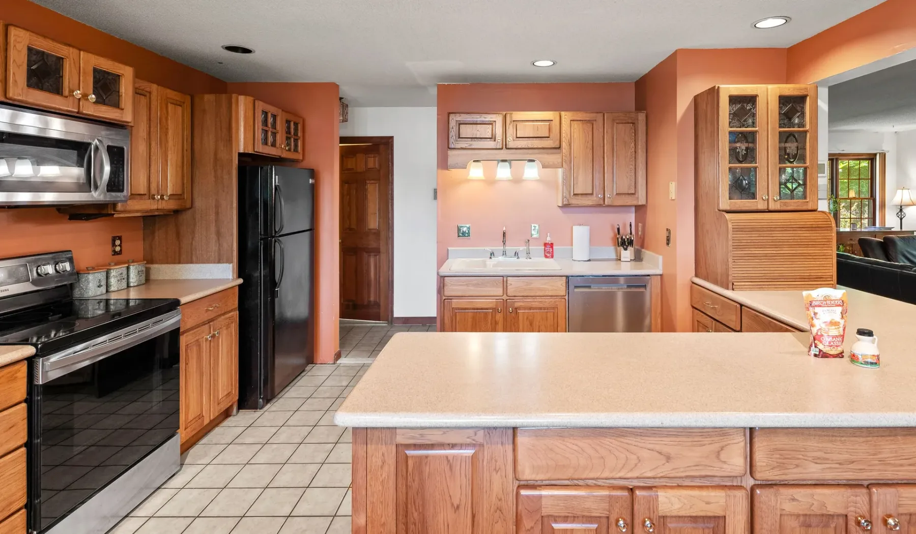 Una cocina con gabinetes de madera, electrodomésticos de acero inoxidable y una isla grande.