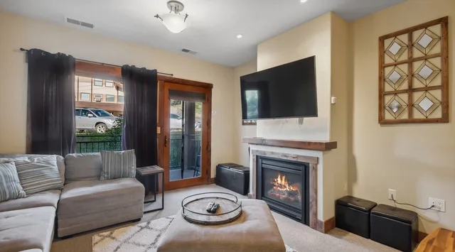 Una sala de estar con asientos, un televisor y una chimenea.