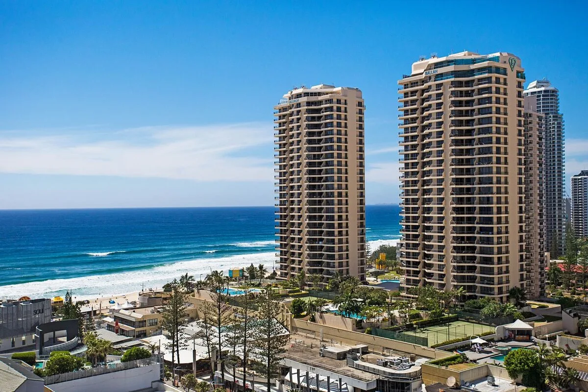 A coastal cityscape with high-rise buildings overlooking the beach and ocean.