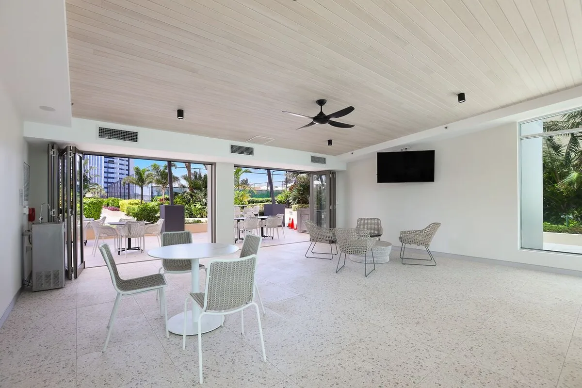 A bright open seating area faces a patio through wide sliding glass doors.