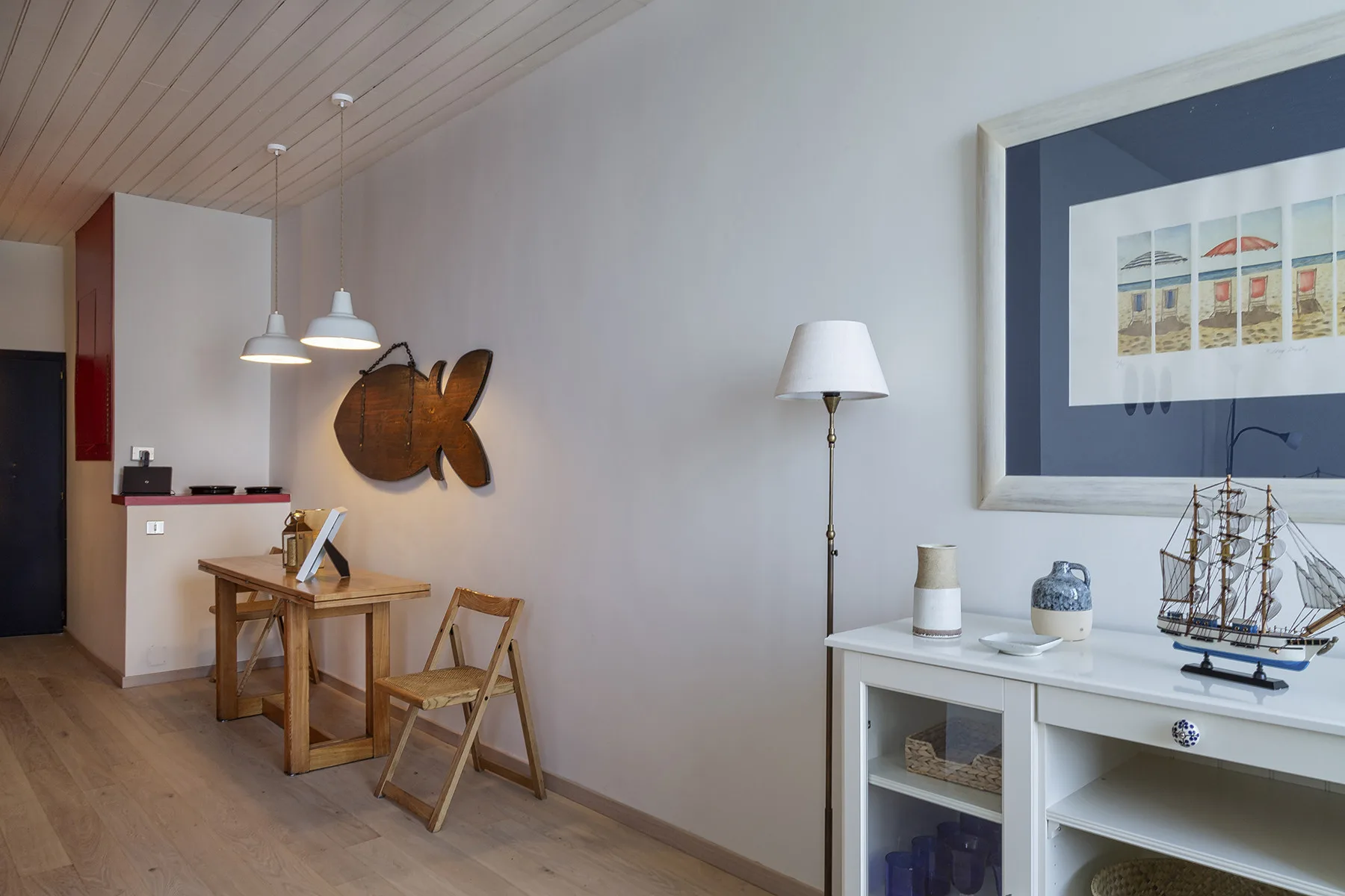 Un comedor con una mesa y sillas de madera junto a un mueble blanco.