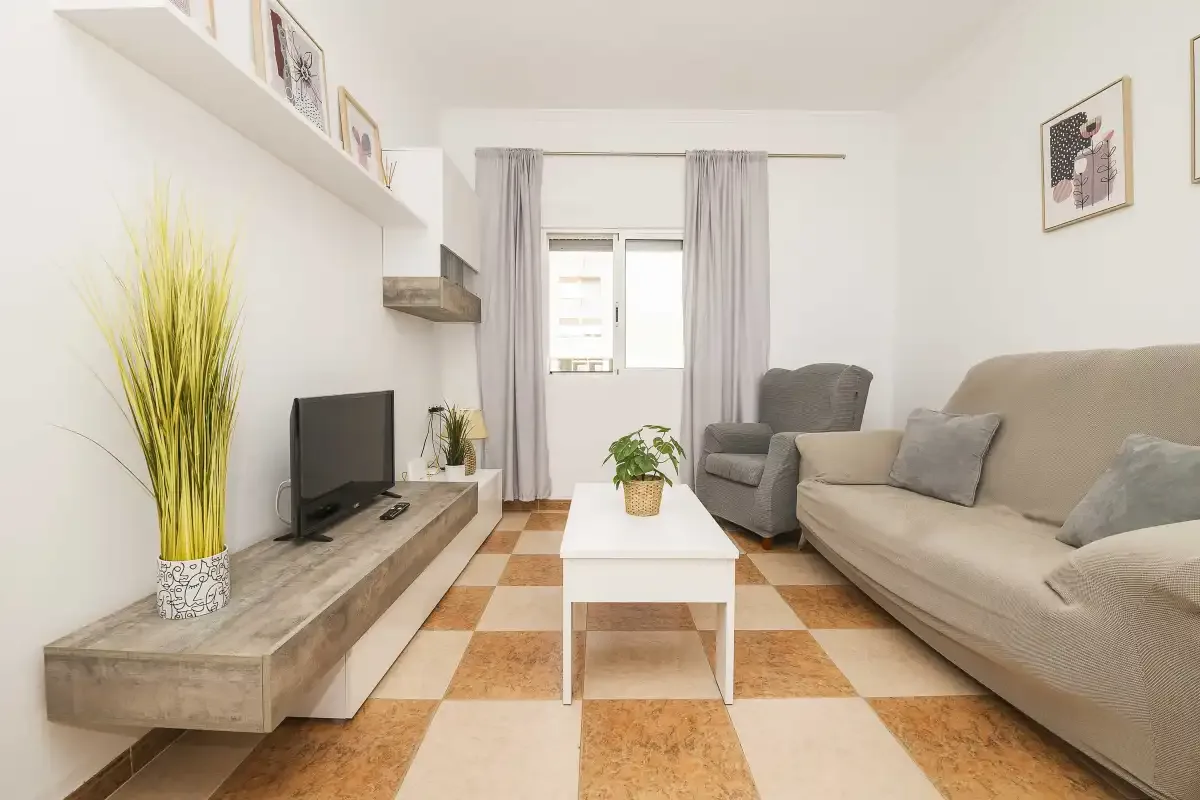 A living room with a television, seating, and a coffee table.