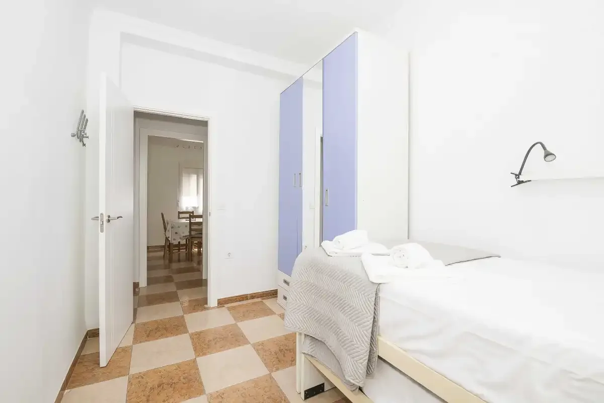 A bedroom with a bed beside an open doorway.