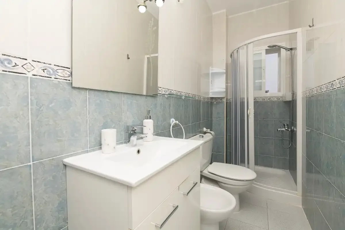A bathroom with a sink, toilet, and shower.